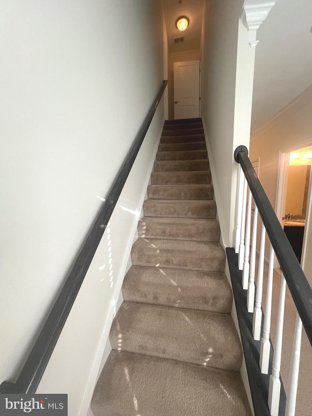 stairway with hardwood / wood-style flooring and decorative columns