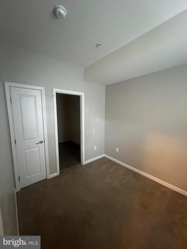 unfurnished bedroom with dark carpet