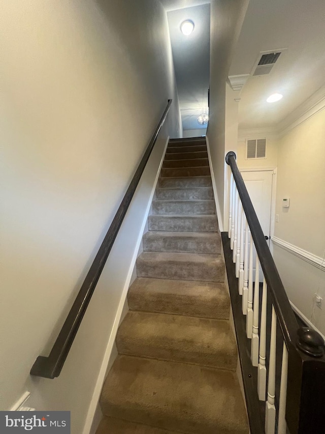 stairway with hardwood / wood-style floors and ornamental molding