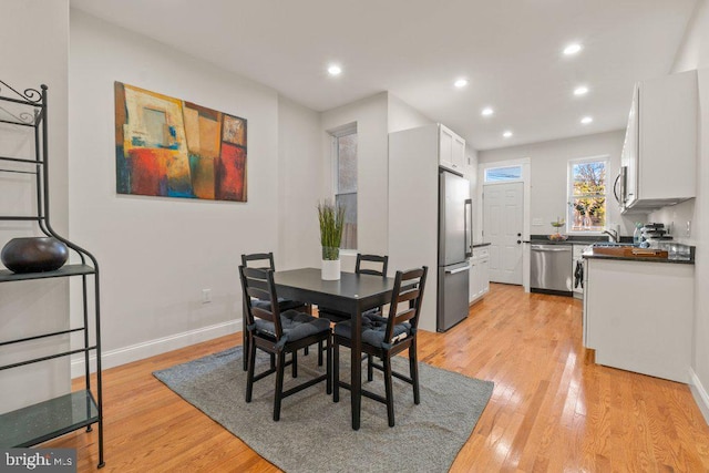 dining area featuring light wood-type flooring and sink