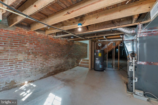 basement with electric water heater, heating unit, and brick wall