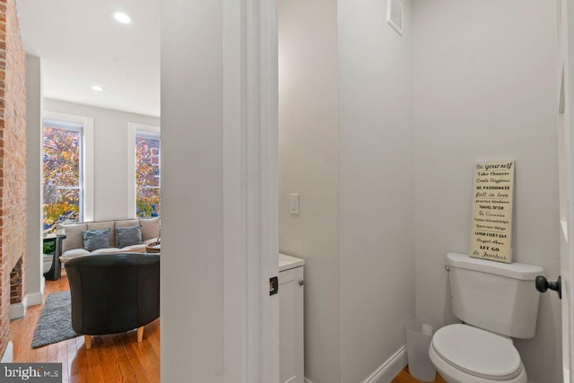 bathroom with wood-type flooring and toilet