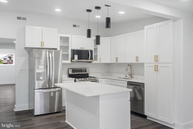 kitchen with sink, decorative light fixtures, a kitchen island, white cabinetry, and stainless steel appliances