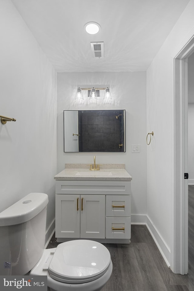 bathroom with hardwood / wood-style flooring, vanity, and toilet