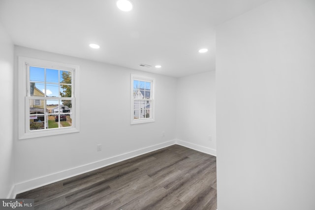 unfurnished room with dark wood-type flooring and a healthy amount of sunlight