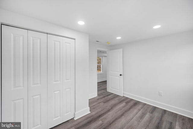 unfurnished bedroom with a closet and wood-type flooring