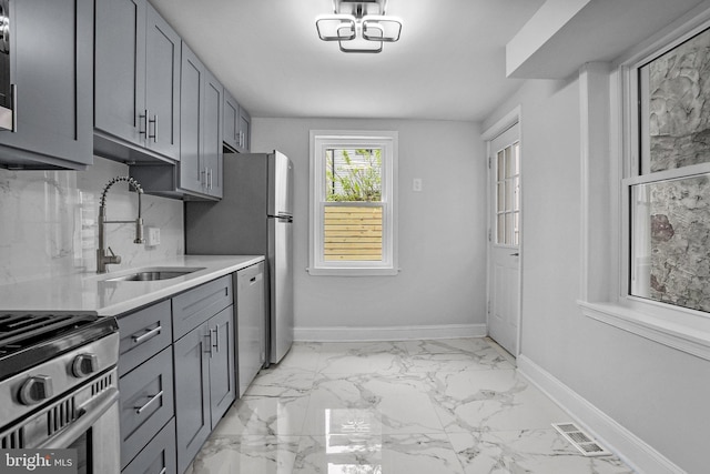 kitchen featuring gray cabinets, stainless steel appliances, and sink