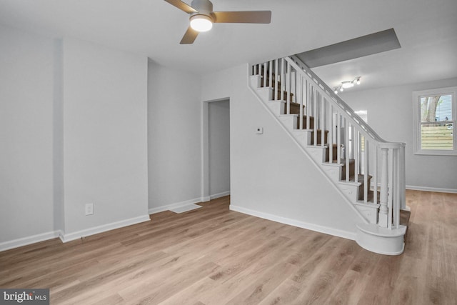 stairs featuring ceiling fan and wood-type flooring