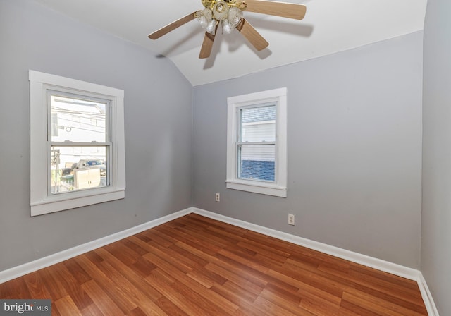 spare room with ceiling fan, wood-type flooring, and vaulted ceiling