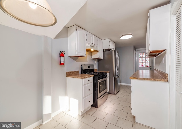 kitchen featuring white cabinets, light tile patterned flooring, and stainless steel appliances