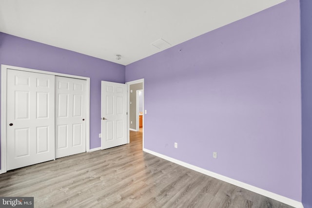 unfurnished bedroom featuring a closet and light hardwood / wood-style floors