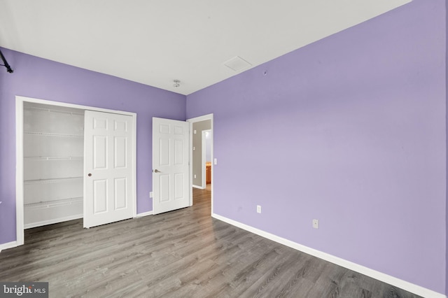 unfurnished bedroom with a closet and hardwood / wood-style flooring