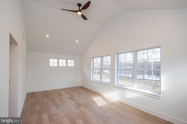 empty room with ceiling fan, plenty of natural light, and light hardwood / wood-style flooring