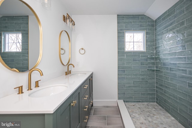 bathroom featuring tiled shower, tile patterned floors, vanity, and vaulted ceiling