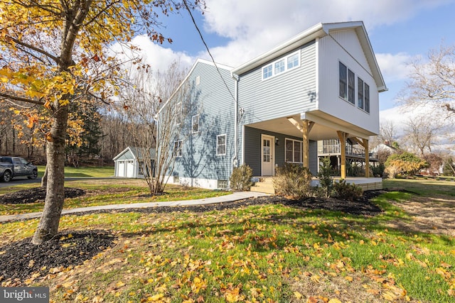 view of front of property featuring covered porch, a shed, and a front yard