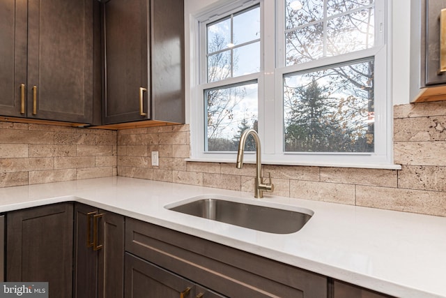 kitchen featuring dark brown cabinets, backsplash, and sink