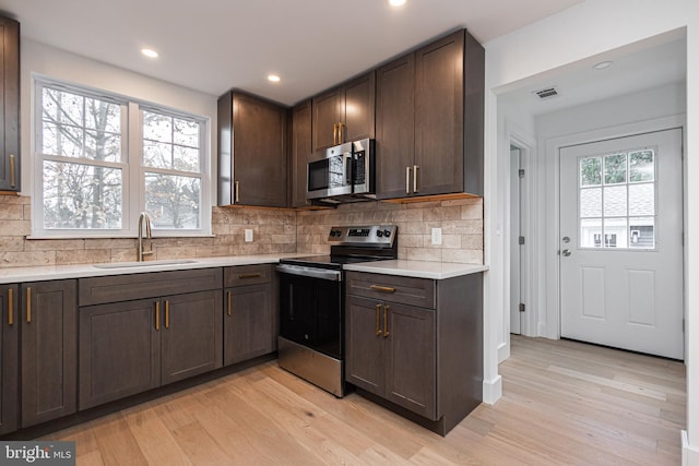 kitchen with appliances with stainless steel finishes, light wood-type flooring, and plenty of natural light