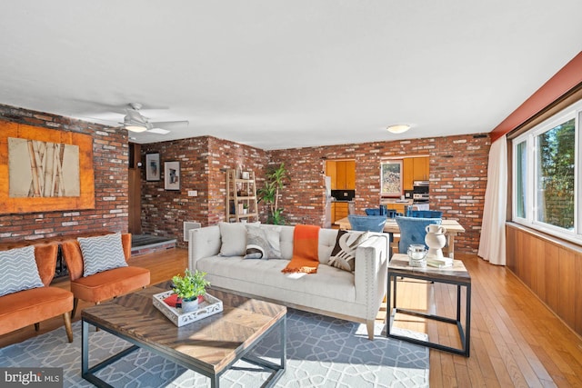 living room with ceiling fan, brick wall, and dark hardwood / wood-style flooring