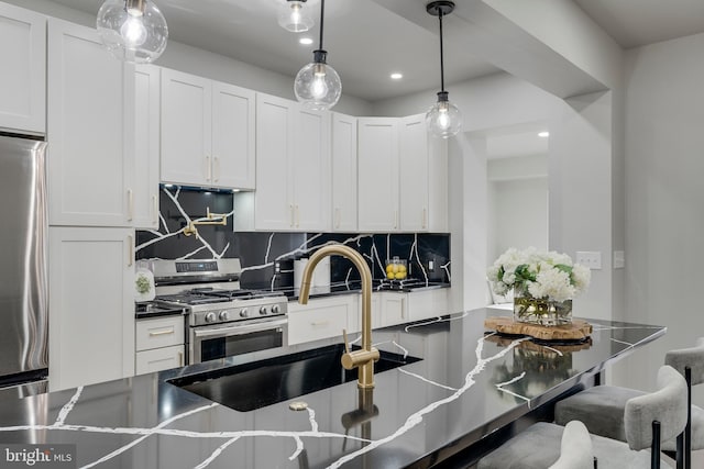 kitchen featuring white cabinetry, stainless steel appliances, a kitchen breakfast bar, decorative light fixtures, and decorative backsplash