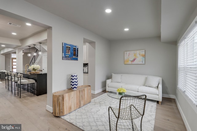 living room featuring a chandelier and light hardwood / wood-style flooring