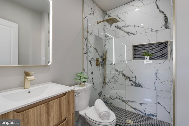 bathroom featuring vanity, toilet, and a tile shower