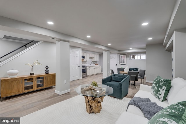 living room featuring light wood-type flooring and sink