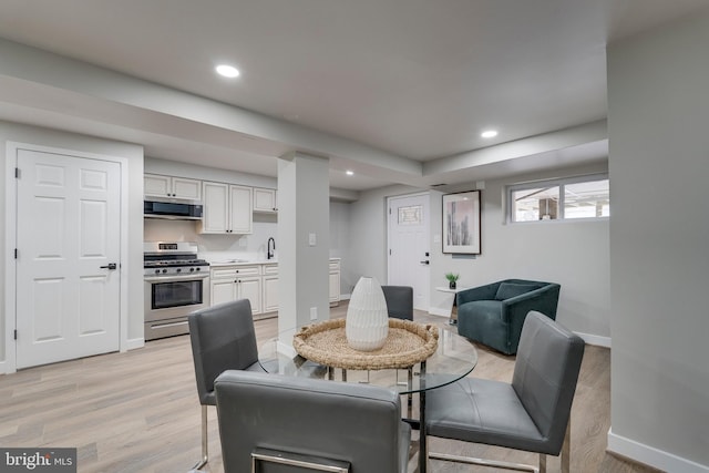 dining area with light hardwood / wood-style floors and sink