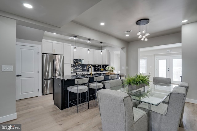 dining area featuring french doors and light hardwood / wood-style floors