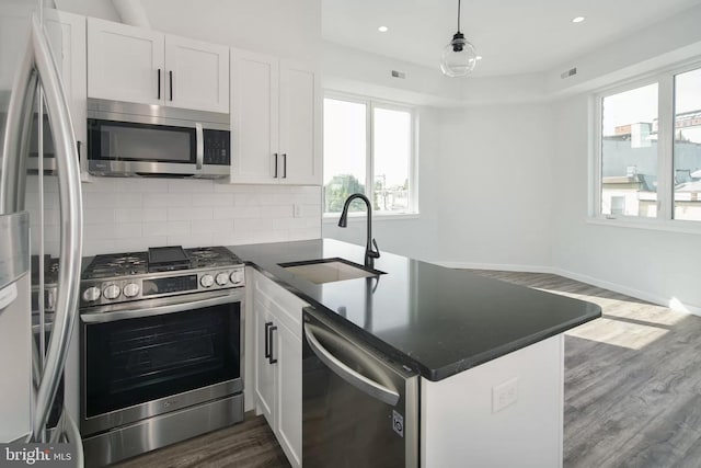 kitchen with a wealth of natural light, sink, white cabinets, and appliances with stainless steel finishes