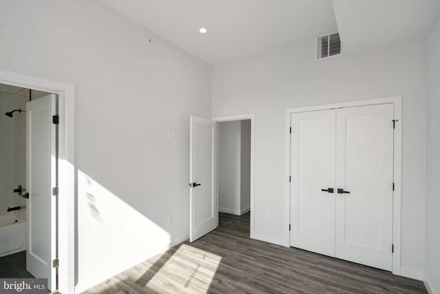 unfurnished bedroom with a closet and dark hardwood / wood-style flooring