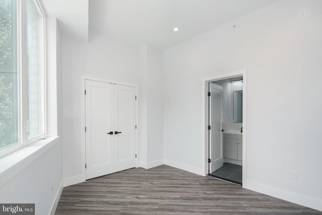 unfurnished bedroom featuring dark wood-type flooring and connected bathroom