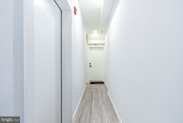 hallway with light hardwood / wood-style floors