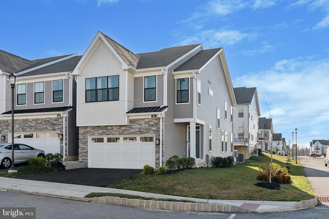 townhome / multi-family property featuring a front yard, a garage, and cooling unit