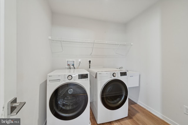 clothes washing area featuring washer and dryer and light wood-type flooring