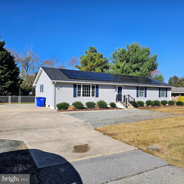 ranch-style house featuring solar panels