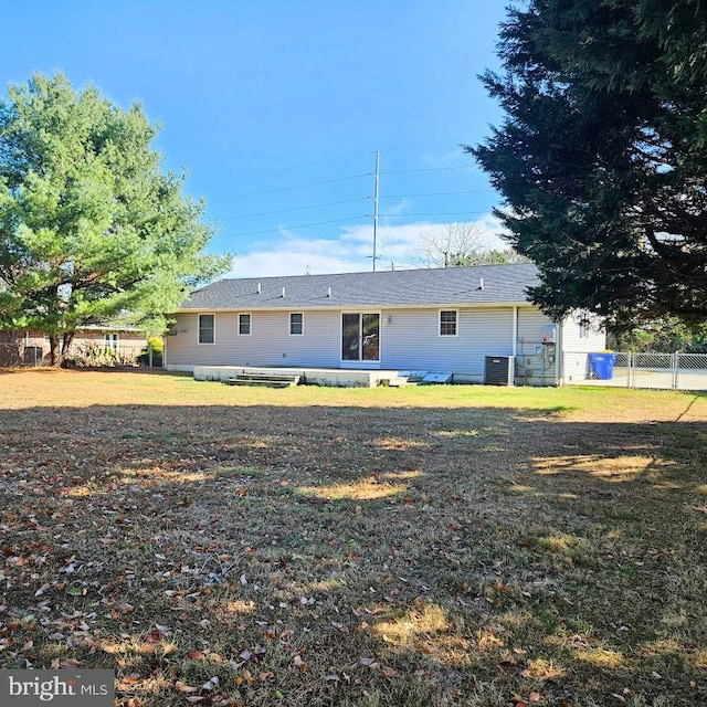 rear view of house with a lawn and central AC