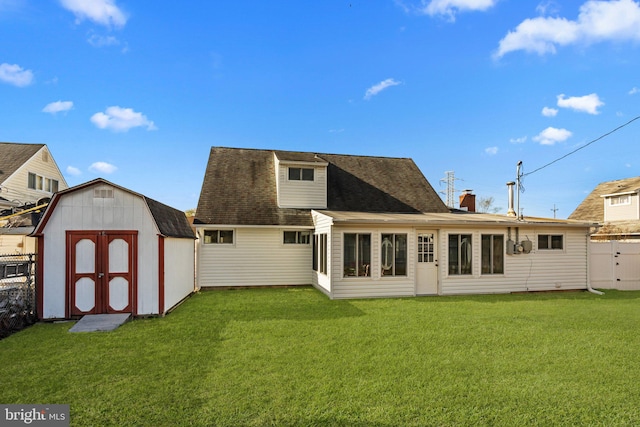 back of house featuring a yard and a shed