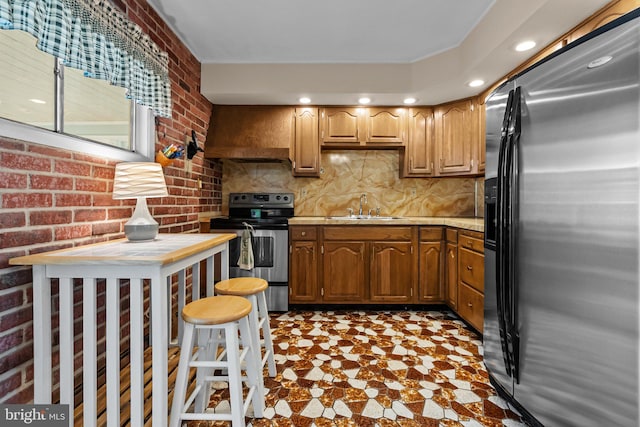 kitchen with sink, custom exhaust hood, brick wall, and appliances with stainless steel finishes