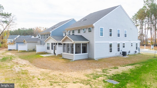 rear view of property featuring central AC unit and a sunroom