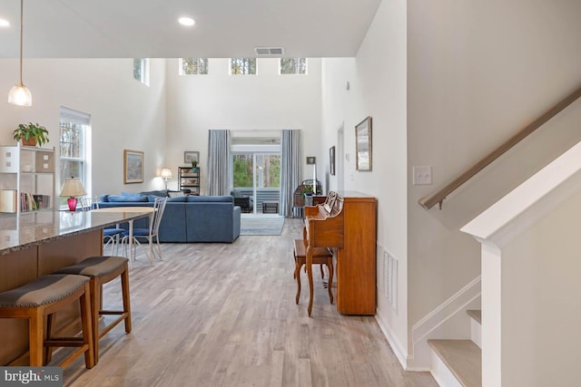 interior space with a high ceiling and light hardwood / wood-style flooring