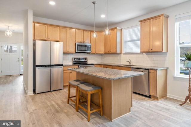 kitchen with a wealth of natural light, sink, stainless steel appliances, and light wood-type flooring