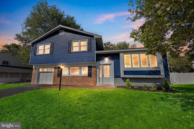 tri-level home featuring a lawn and a garage