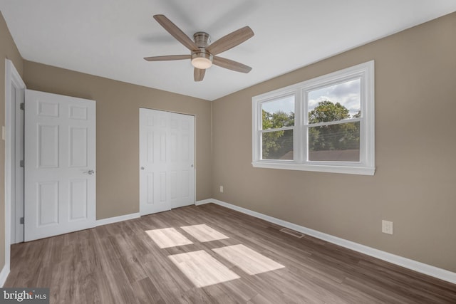 unfurnished bedroom featuring ceiling fan, a closet, and light hardwood / wood-style floors