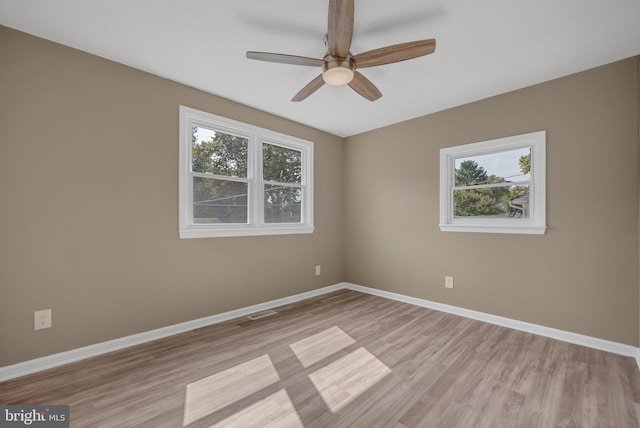 spare room featuring light hardwood / wood-style floors, a wealth of natural light, and ceiling fan