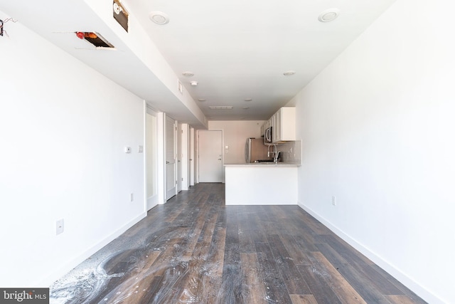 unfurnished living room with dark wood-type flooring and sink