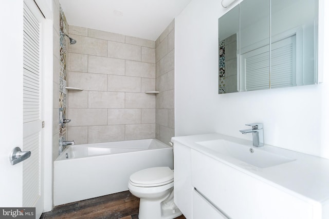 full bathroom featuring wood-type flooring, vanity, toilet, and tiled shower / bath