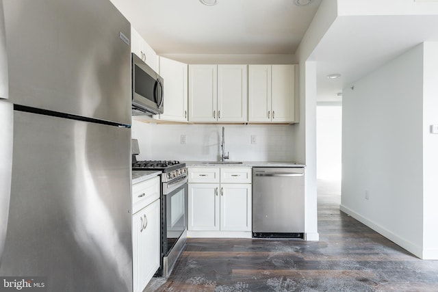 kitchen featuring stainless steel appliances, white cabinetry, dark wood-type flooring, and sink