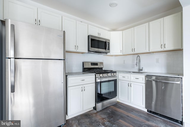 kitchen featuring sink, stainless steel appliances, dark hardwood / wood-style floors, decorative backsplash, and white cabinets