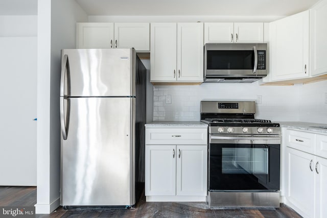 kitchen with white cabinets, stainless steel appliances, and dark wood-type flooring