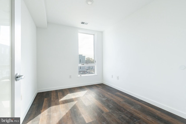 empty room with dark hardwood / wood-style flooring